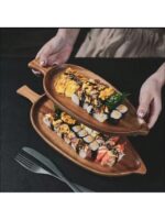 Leaf wooden platter on a black table with food on it.